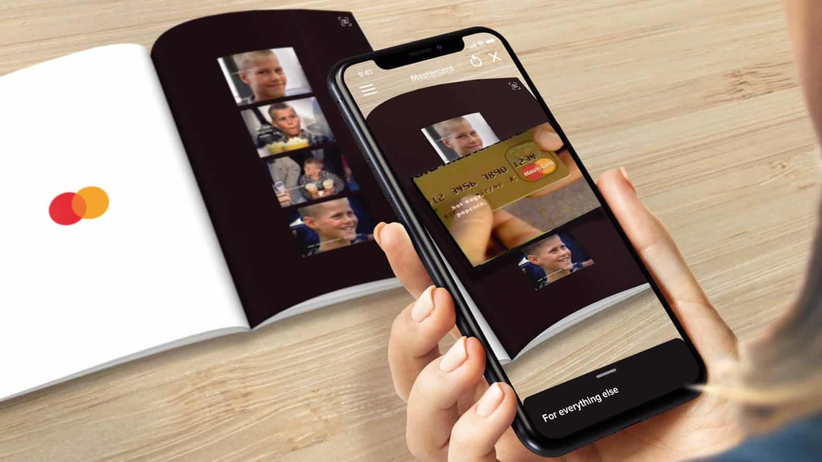 A phone being used to scan a Mastercard brochure revealing a gold card in AR.