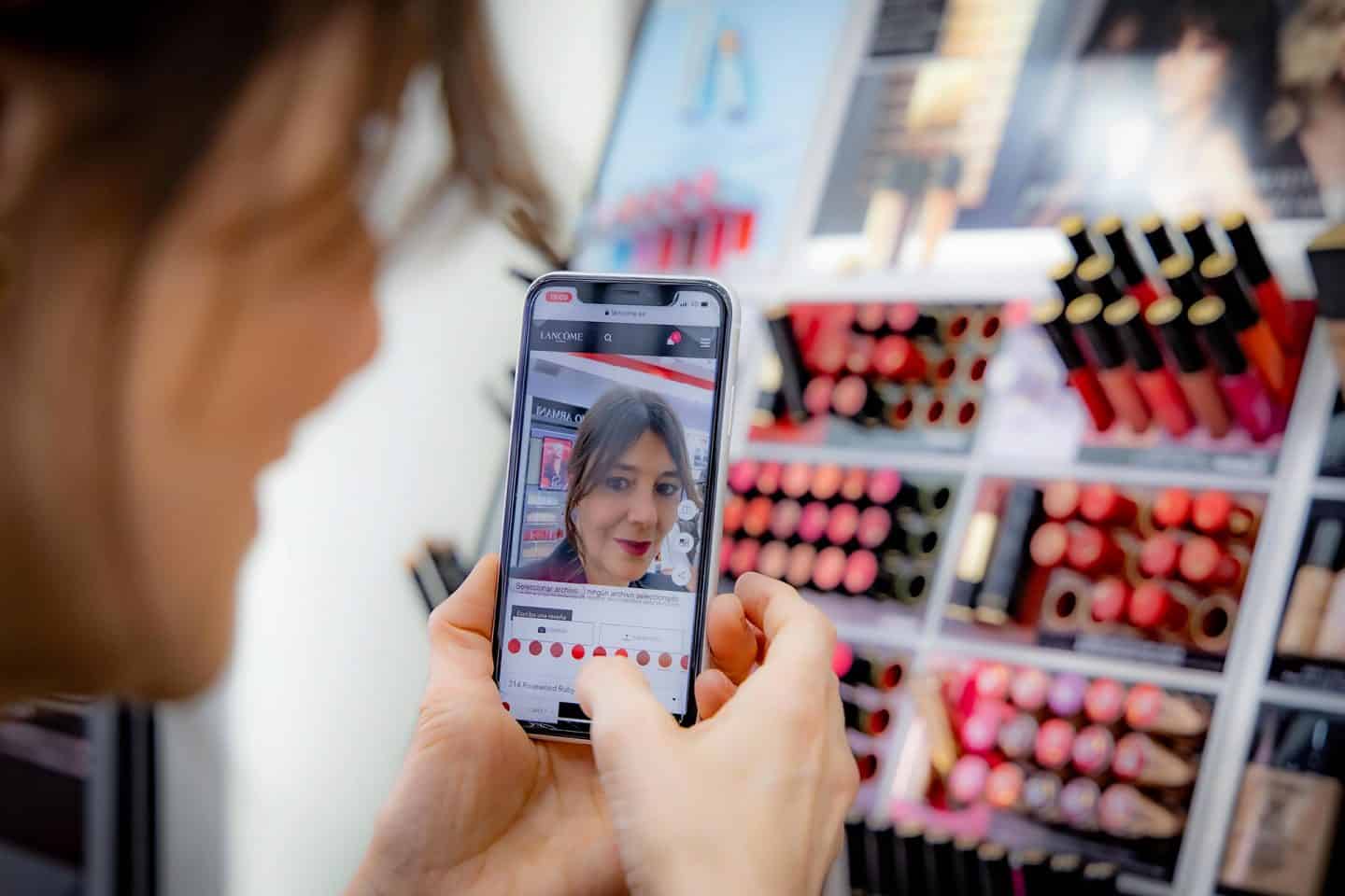 A woman using a try before you buy makeup app testing out lipstick colour.