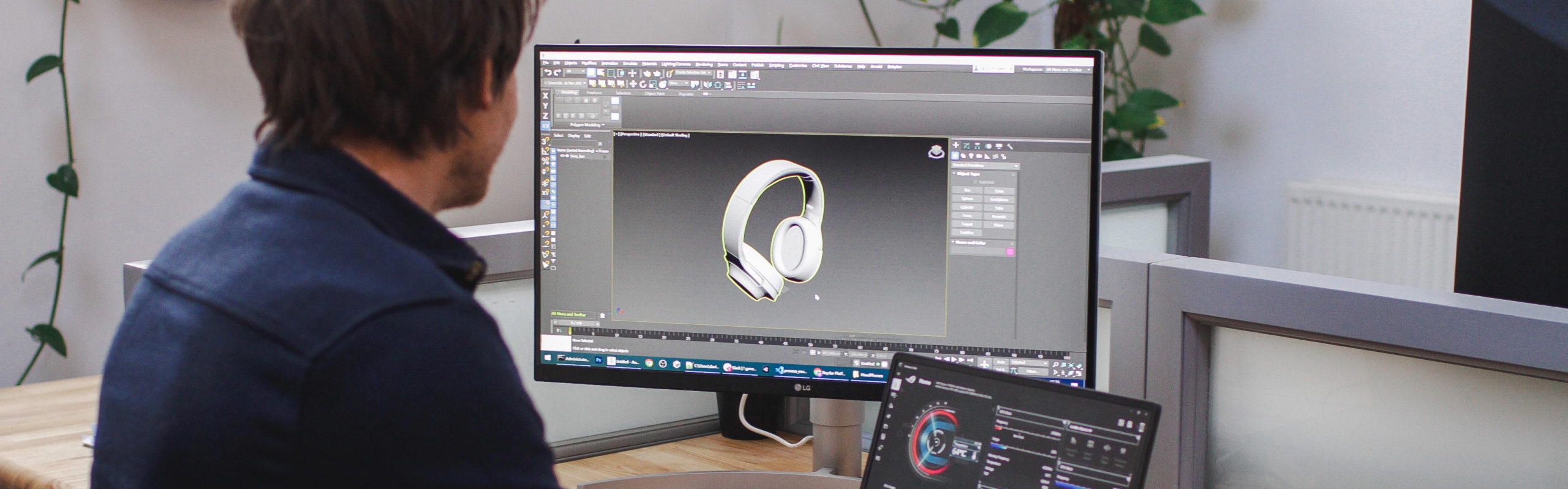 A man facing his computer screen using software to model 3D headphones.