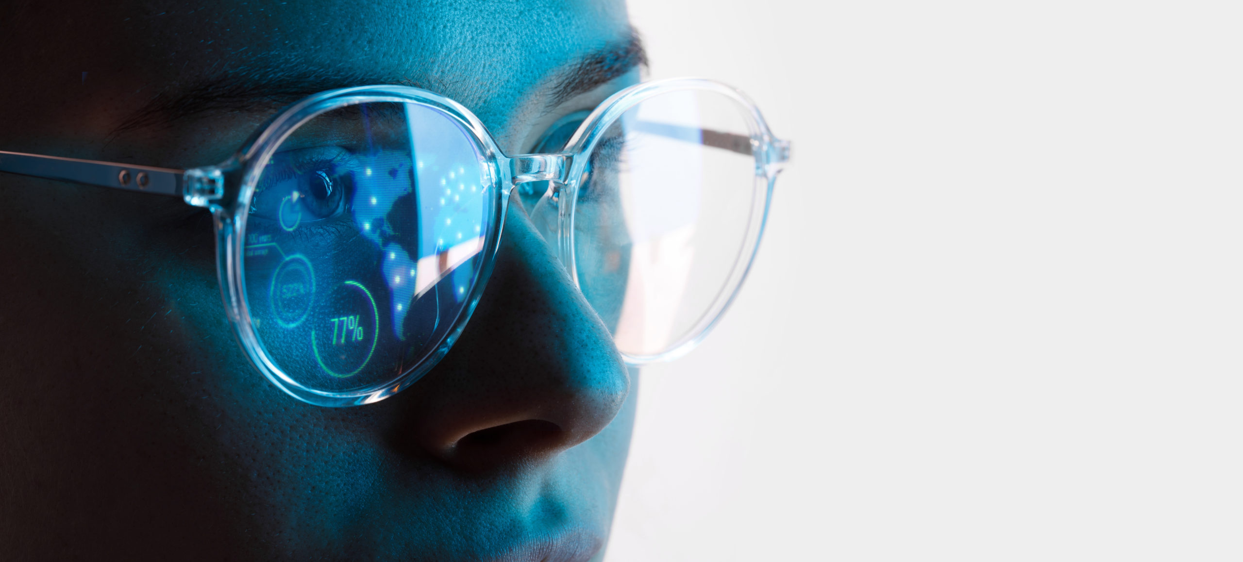 A close up of a person wearing AR glasses that has information displayed in one of the lenses.